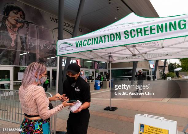 Guest shows her digital vaccine card to the security guard before entering the 90's Nostalgia Electric Circus Edition concert at Abbotsford Centre on...