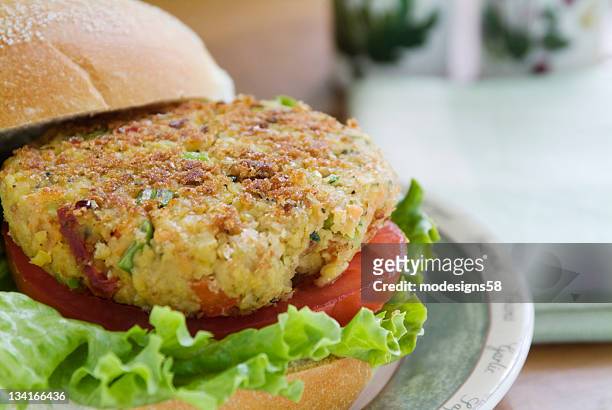 close-up of a veggie burger with lettuce and tomatoes - veggie burger stock pictures, royalty-free photos & images