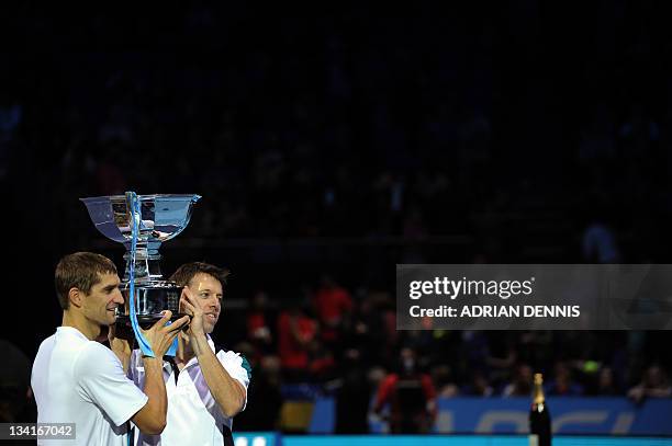 Max Mirnyi of Belarus and his partner Daniel Nestor of Canada hold up their ATP World Tour Finals tennis tournament doubles champions' trophy after...