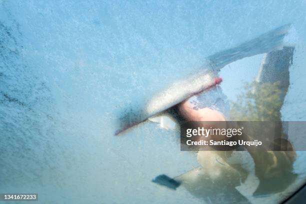 cleaning ice from a car windshield seen from the inside - cleaning inside of car stock pictures, royalty-free photos & images