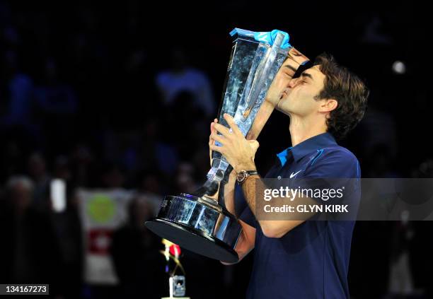 Roger Federer of Switzerland kisses the ATP World Tour Finals tennis tournament singles trophy after beating Jo-Wilfried Tsonga of France in the...