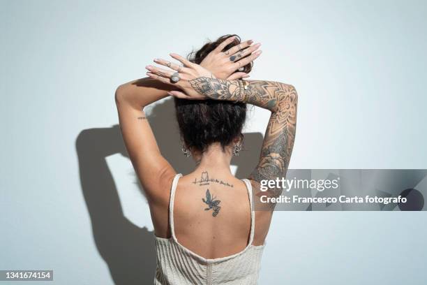 rear view of a young woman with tattoo - tatoeage stockfoto's en -beelden