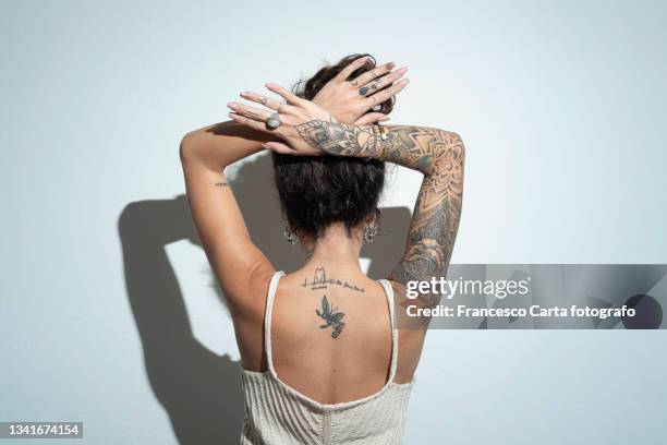 rear view of a young woman with tattoo - rug handen zij stockfoto's en -beelden