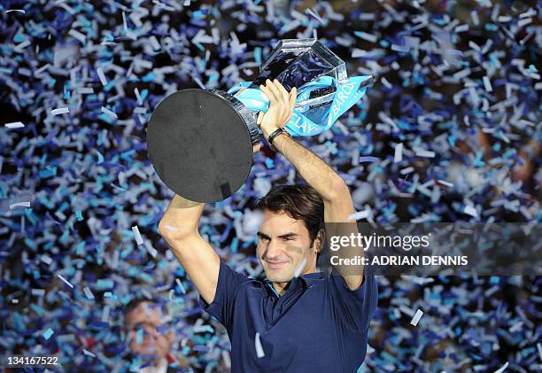 Roger Federer of Switzerland poses with the ATP World Tour Finals tennis tournament singles trophy after beating Jo-Wilfried Tsonga of France in the...