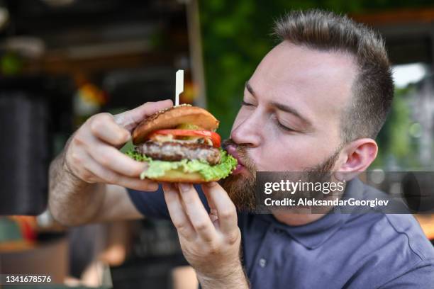 hungry male eating delicious burger - veggie burger stock pictures, royalty-free photos & images
