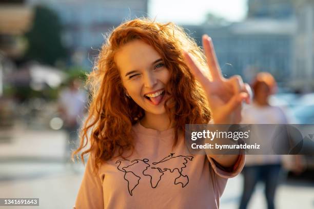 hübsche frau mit brille, die siegesgeste zeigt - zwei finger stock-fotos und bilder