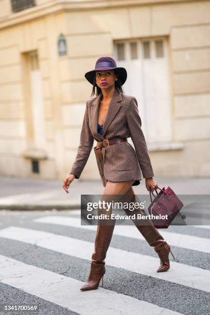 Emilie Joseph @in_fashionwetrust wears silver and gold earrings, a burgundy felt fedora Virginie hat from Maison Michel, a brown prince of Wales...