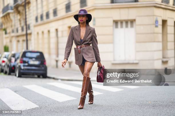 Emilie Joseph @in_fashionwetrust wears silver and gold earrings, a burgundy felt fedora Virginie hat from Maison Michel, a brown prince of Wales...