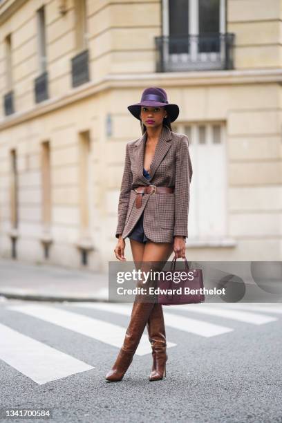 Emilie Joseph @in_fashionwetrust wears silver and gold earrings, a burgundy felt fedora Virginie hat from Maison Michel, a brown prince of Wales...