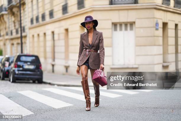 Emilie Joseph @in_fashionwetrust wears silver and gold earrings, a burgundy felt fedora Virginie hat from Maison Michel, a brown prince of Wales...