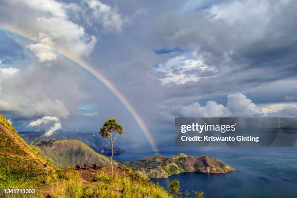 rainbow above the hill on the shores of lake toba - lake toba sumatra stock pictures, royalty-free photos & images