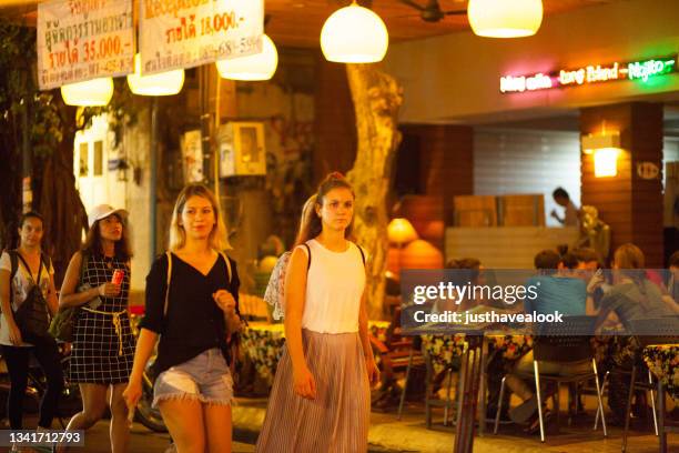 front view of two caucasian women walking in khao san road - khao san road stock pictures, royalty-free photos & images