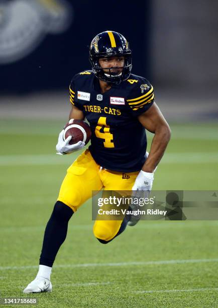 Papi White of the Hamilton Tiger-Cats runs with the ball during a CFL game against the Calgary Stampeders at Tim Hortons Field on September 17, 2021...