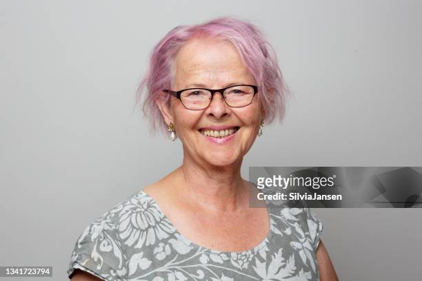 portait of a senior woman with pink hair, smiling - older woman colored hair stock pictures, royalty-free photos & images