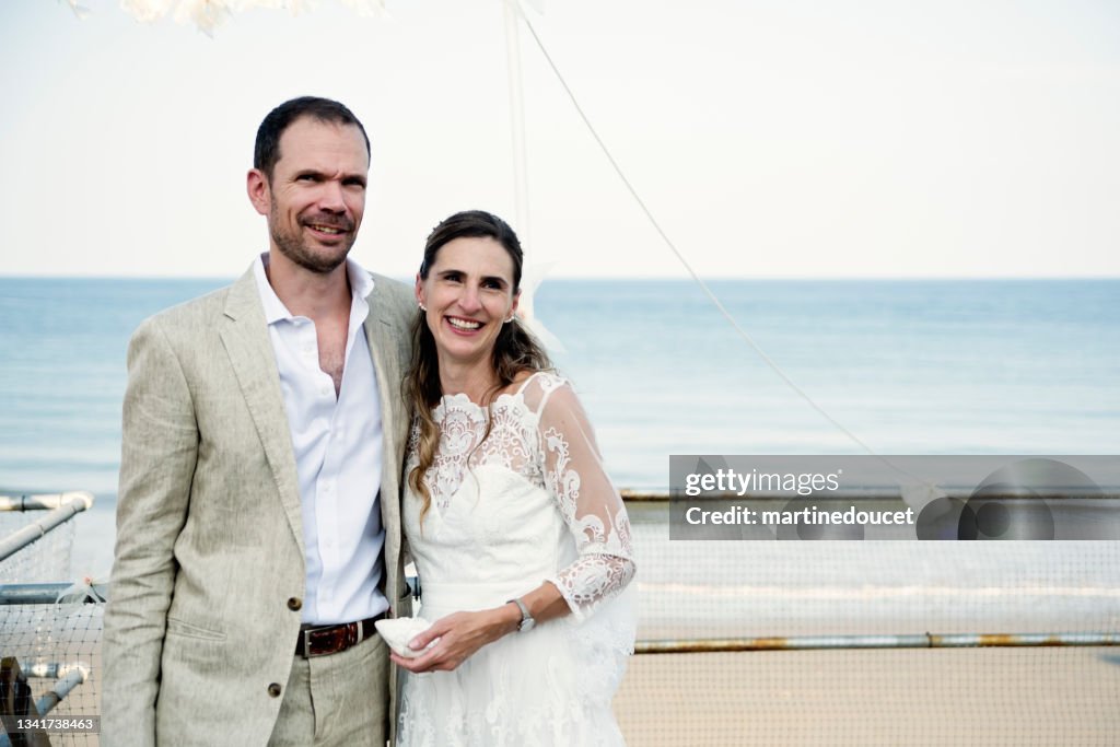 Newlywed portrait at small wedding ceremony in family beach house.