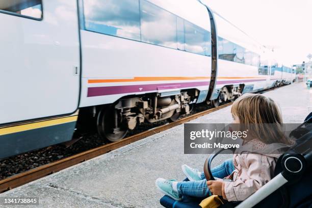 niña en una estación de tren viendo la llegada del tren. - train platform fotografías e imágenes de stock