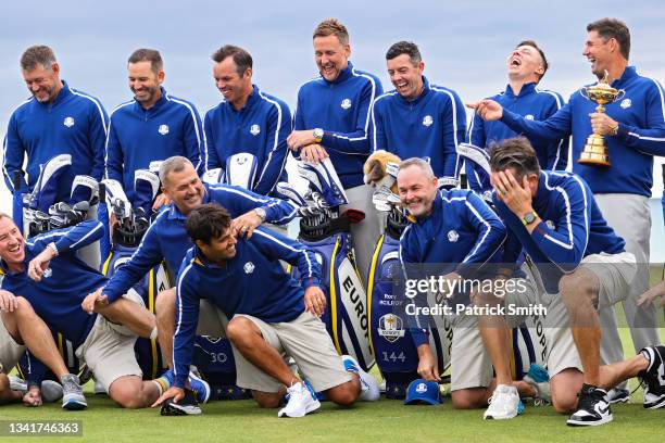 Caddies for Team Europe and players of Team Europe joke around as captain Padraig Harrington holds the Ryder Cup during a team photoshoot prior to...