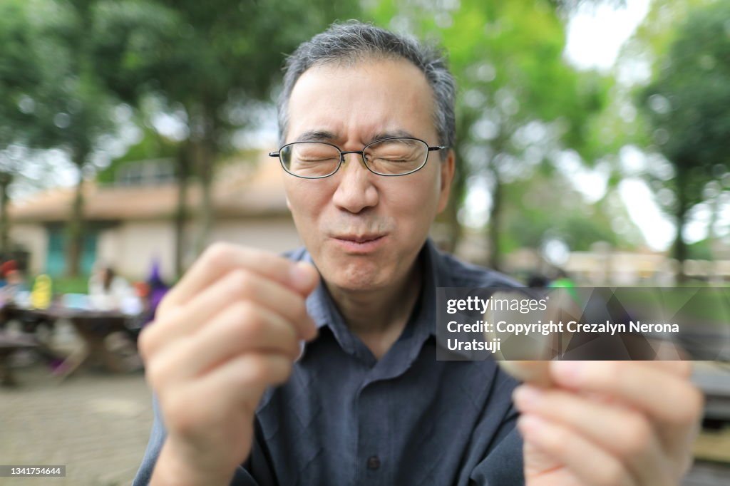 Man Eating Sour Biscuit Making a Funny Face