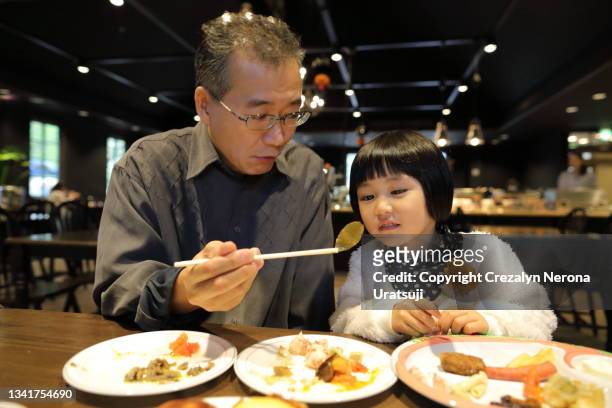 father and child quality time bonding eating in a resturant - fathers day dinner stock pictures, royalty-free photos & images