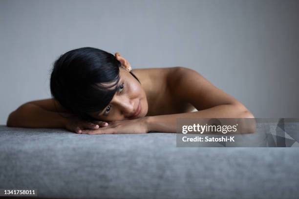 portrait of asian woman relaxing in living room - カッコいい stockfoto's en -beelden