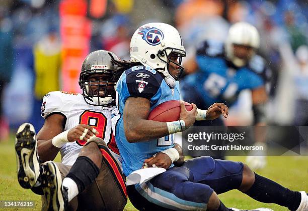 Tim Crowder of the Tampa Bay Buccaneers tackles Chris Johnson of the Tennessee Titans during play at LP Field on November 27, 2011 in Nashville,...