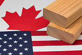Softwood construction lumber on flag of Canada and United States of America. Trade war, tariffs, fair trade and lumber, logging industry concept