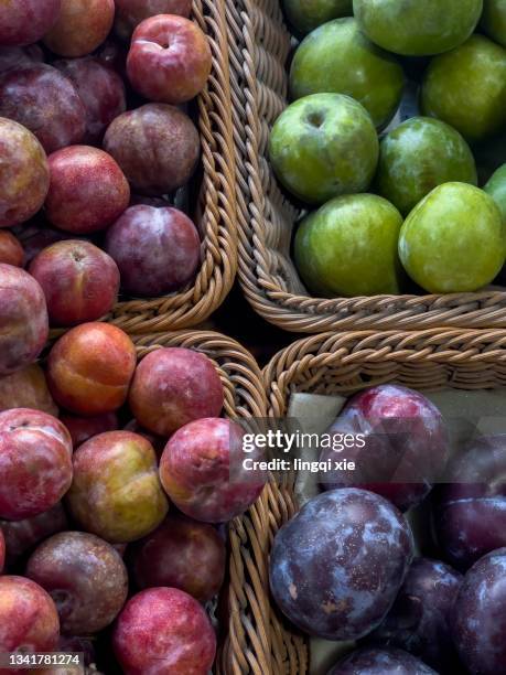 plums in a square basket - red plum stock pictures, royalty-free photos & images