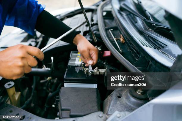 selective focus  hand of motor car mechanic checking and replacing new battery and fix it - vehicle breakdown imagens e fotografias de stock