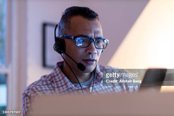 man working online from his home office - stock market traders stock pictures, royalty-free photos & images