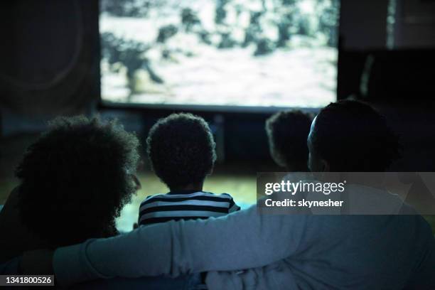 movie night at home! - african american watching tv stock pictures, royalty-free photos & images