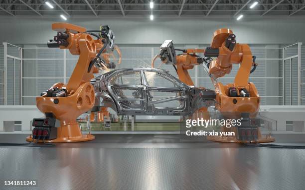 assembly line of robots welding car body - automobilbau stock-fotos und bilder