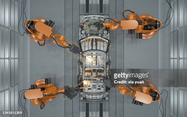 assembly line of robots welding car body - brazo robótico fotografías e imágenes de stock