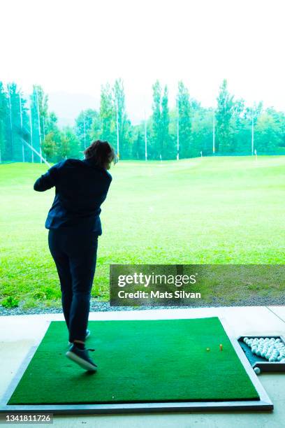 golfer training her golf club driver on driving range in a sunny day - mats silvan stock pictures, royalty-free photos & images