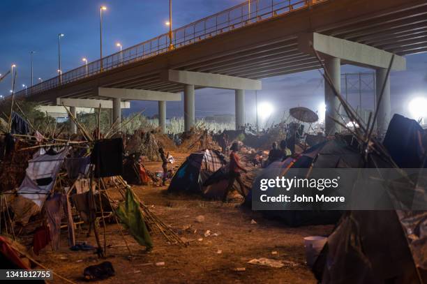 Boy bathes himself with a jug of water inside a migrant camp at the U.S.-Mexico border on September 21, 2021 in Del Rio, Texas. The immigrants,...