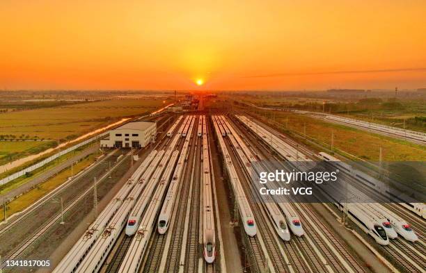 Bullet trains wait to run at sunrise during the Mid-Autumn Festival on September 21, 2021 in Nantong, Jiangsu Province of China.