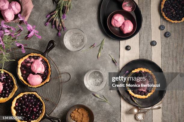 blueberrypie with lavender ice cream in black plates with lavender flowers - blueberry pie stock pictures, royalty-free photos & images