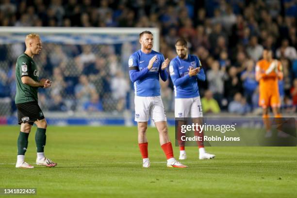 Ryan Broom of Plymouth Argyle and Ryan Tunnicliffe and Kieron Freeman of Portsmouth FC clap on the 10 minute mark in memory of Sophie Fairall, a...