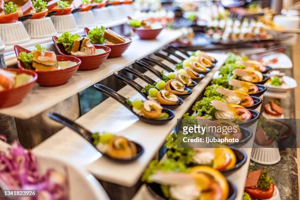 buffet table full of food - finger food stockfoto's en -beelden