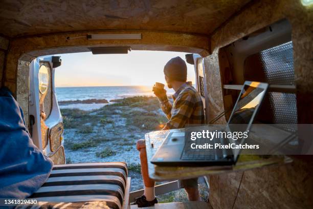 man takes a break working on laptop in back of camper van - camping car stock pictures, royalty-free photos & images