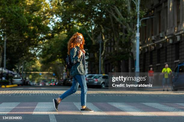 woman crossing road to other side in big city - approaching bildbanksfoton och bilder