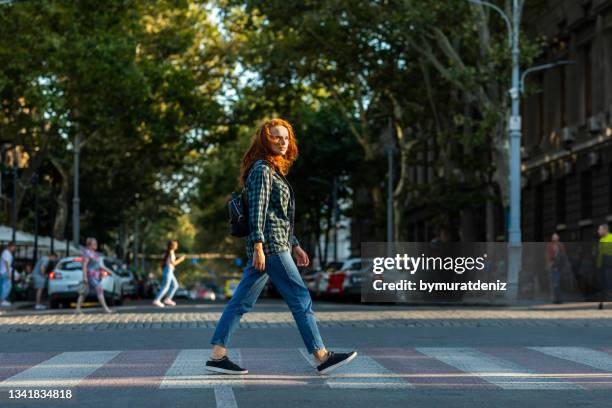 woman crossing road to other side in big city - san francisco street stockfoto's en -beelden