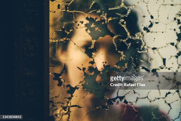 young woman reflection on the damaged mirror - schizophren stock-fotos und bilder