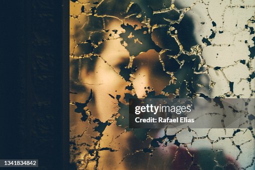 Young woman reflection on the damaged mirror Young woman reflection on the damaged mirror