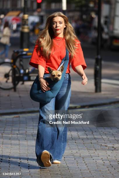 Becky Hill carries her pet dog as she leaves Capital Breakfast Radio Studios on September 22, 2021 in London, England.