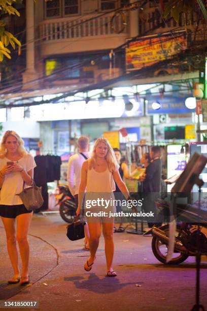 blond caucasian tourist women are walking in khao san road at night - khao san road stock pictures, royalty-free photos & images