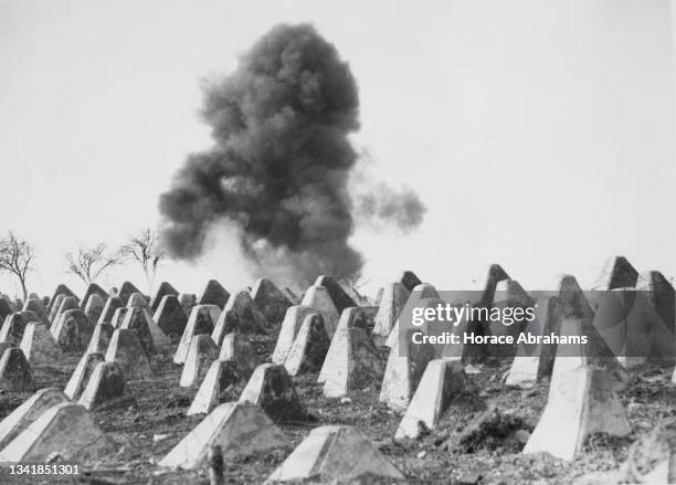 Engineers of the United States Seventh Army use explosives to destroy sections of Dragons Teeth anti tank defences of the Siegfried Line to make...