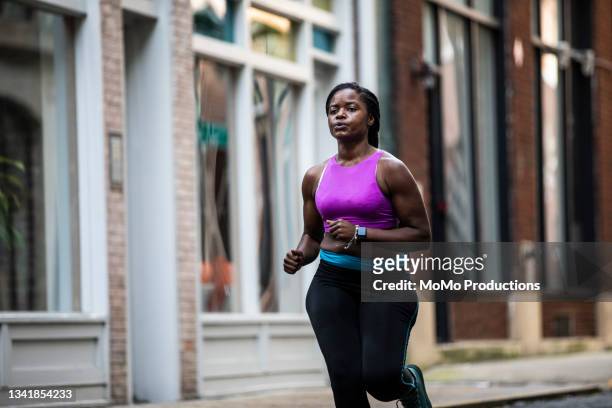 female running through urban area - training center stock pictures, royalty-free photos & images
