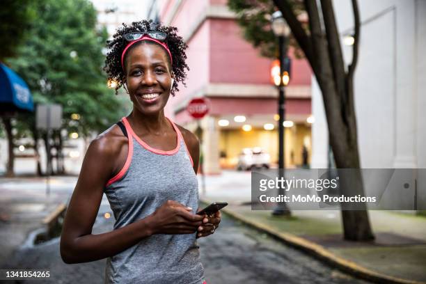 female runner using mobile device in urban area - open workouts stockfoto's en -beelden