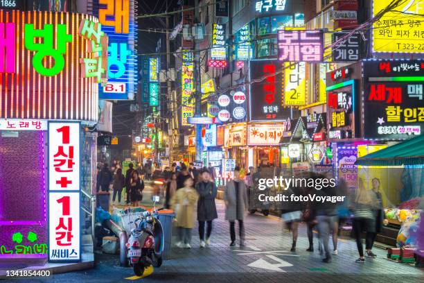 seoul people walking through neon drenched night streets sinchon korea - namsan seoul bildbanksfoton och bilder