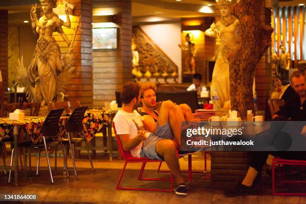 relaxed sitting two caucasian backpacker tourists are sitting at restaurant in khao san road - khao san road stock pictures, royalty-free photos & images